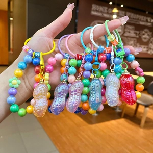 Gros plan de breloques en forme de cacahuètes colorées avec perles de lettres sur porte-clés