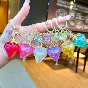 Macro detail of colorful strawberry resin keychains with gold plating and faceted beads