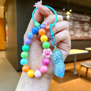 Vue détaillée d'un pendentif cacahuète bleu translucide et de perles colorées sur un porte-clés