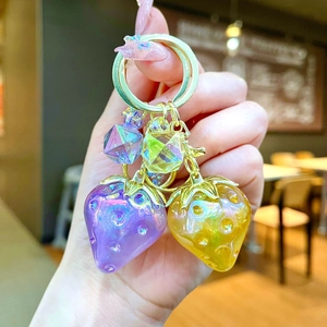 Close-up of translucent strawberry charms with gold plating and faceted crystals