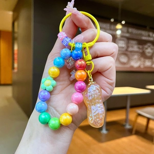 Gros plan d'un porte-clés en perles arc-en-ciel avec un pendentif cacahuète nacré