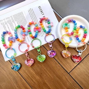 Luminous heart-shaped quicksand keychain with colorful beads and butterfly charm