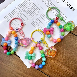 Detailed view of colorful beaded heart keychains with ribbons and letter charms