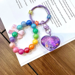 Detailed view of handmade luminous heart charm with beads and pink resin bow
