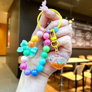 Close-up of heart-shaped liquid glitter pendant and colorful beads keychain