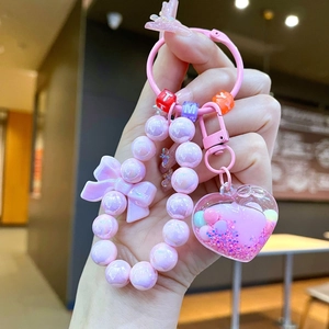 Portachiavi con perline rosa con ciondolo a cuore a sabbie mobili e fiocco decorativo