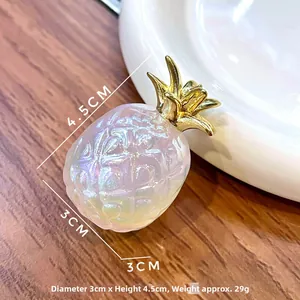 Macro view of a 4.5cm iridescent resin pineapple pendant with golden leaves