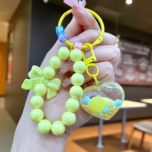Dettaglio portachiavi a perle gialle con perle alfabeto e ciondolo a cuore blu
