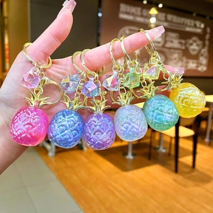 Close-up of colorful resin pineapple pendants with gold keychains in six vibrant shades