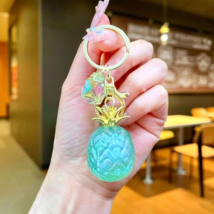Iridescent pineapple keychain charm featuring translucent resin and gold metal leaf detail
