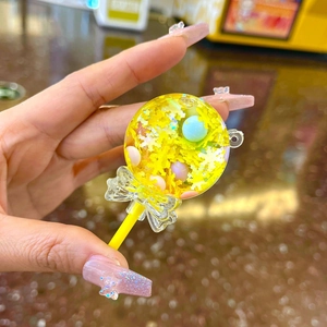 Dettaglio del portachiavi a lecca-lecca giallo con paillettes e perle colorate