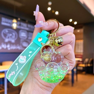 Gros plan d'un porte-clés patte de chat en sables mouvants verts avec bracelet silicone