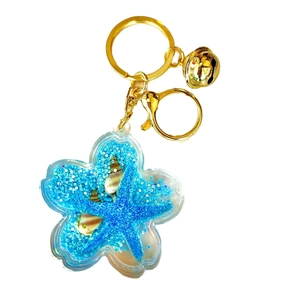 Ocean themed starfish flower keychain with blue glitter liquid and gold bell accessory
