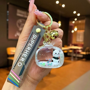Close-up of a panda liquid keychain with sequins and superhero silicone wristband