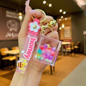 Detailed shot of pink silicone honey strap and acrylic liquid sand keychain charm