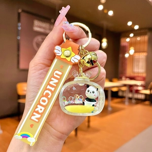 Detail of panda floating in liquid sand keychain with golden bell and orange unicorn strap