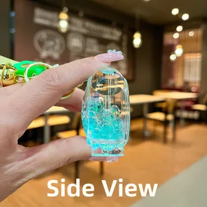 Vista laterale del portachiavi liquido con bolle blu, campanello dorato e ciondolo a petalo