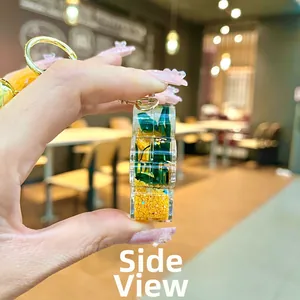 Side view of acrylic rectangular keychain with miniature green plants and golden ring