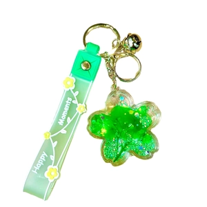 Floral oil-filled keychain with green sequin flower charm and Happy Moments wrist strap