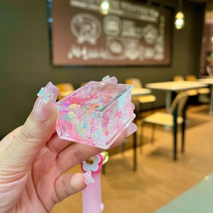 Close-up of pink acrylic liquid sand keychain filled with glitter and stars sequins