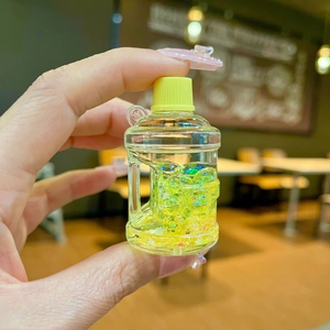 Luminous acrylic bucket keychain with yellow cap and sparkling green liquid glitter