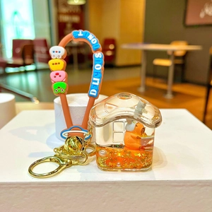 Detail of transparent house-shaped earphone case with Capybara mascot and brown silicone strap