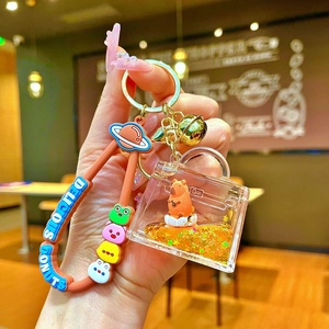 Detail of Capybara liquid quicksand keychain with orange sequins and brown silicone strap