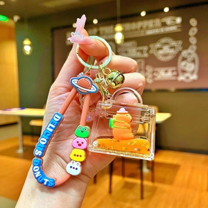 Detail of Capybara liquid sand keychain with orange charm and brown silicone strap