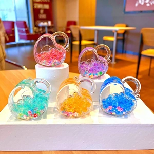 Close-up of five heart-shaped liquid-filled keychains with colorful beads and sequins