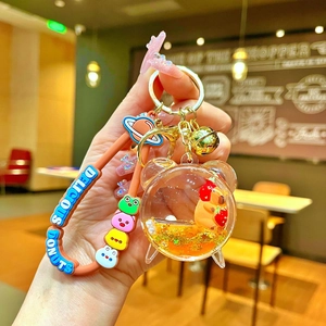 Detail of Capybara liquid quicksand keychain with strawberry hat and silicone wristband