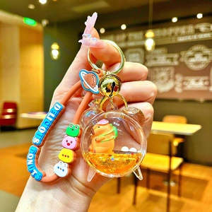 Close-up of creative bear-shaped water oil keychain with liquid glitter and capybara figure