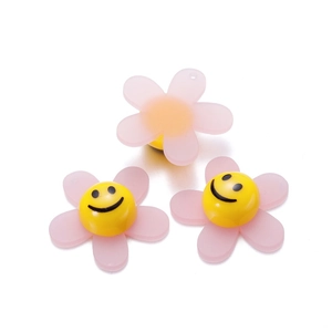 Detail of pink acrylic sunflower charms with smiling faces for DIY jewelry making