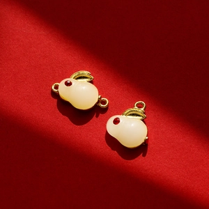 Détail macro du pendentif lapin en imitation jade avec cadre doré et strass rouge