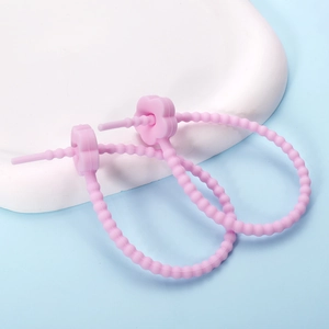 Close-up of pink flower silicone cable ties with flexible beaded strap on blue background