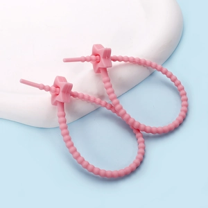 Detail of pink silicone star cable ties showing bead texture and secure locking mechanism