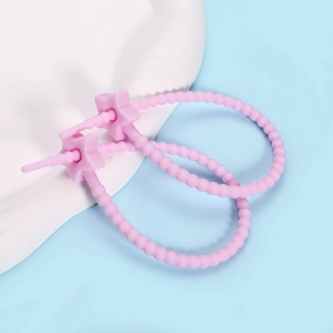 Macro shot of pink silicone star cable tie with adjustable bead chain for organization