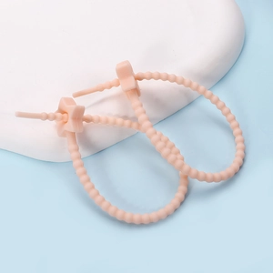 Detail view of pink silicone cable ties with star-shaped buckles for wire management