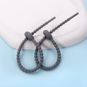 Close-up of gray silicone cable ties with non-slip bead design on a white tray