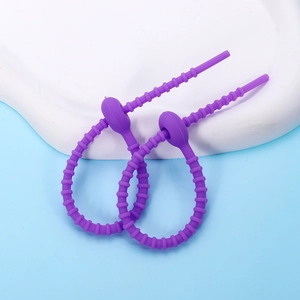 Detail of adjustable purple silicone cable ties with bead chain design on white plate