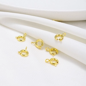 Macro view of six polished 18K gold-plated spring ring clasps for jewelry making