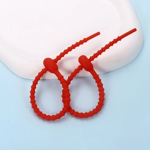 Macro view of red silicone cable ties with non-slip ridges for versatile cord organization