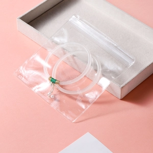 Transparent PVC jewelry storage bag with a pearl-decorated hair ring and green thread details