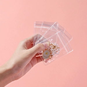 Detailed view of thickened transparent PVC jewelry bag with resealable seal and pearl necklace