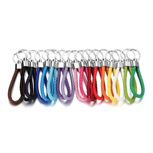 Detailed flat lay of colorful braided leather keychains with silver metal key rings