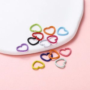 Close-up of textured heart-shaped open jump rings in assorted matte paint colors for DIY