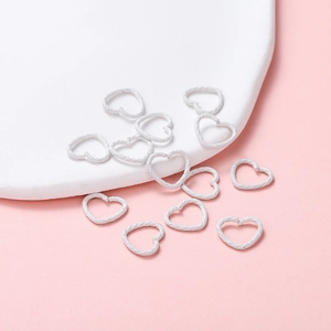 Macro shot of white matte heart-shaped jump rings for DIY handmade jewelry connecting