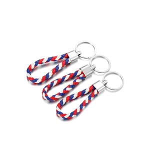 Detailed view of three braided leather keychains in red, white and blue colors