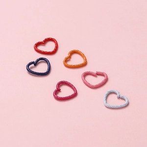 Macro shot of colorful heart-shaped jump rings with hammered texture for DIY jewelry crafts
