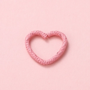 Macro shot of pink heart-shaped open ring with unique textured finish for DIY jewelry