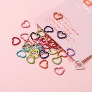 Macro detail of heart-shaped metal connector rings with a unique matte textured finish